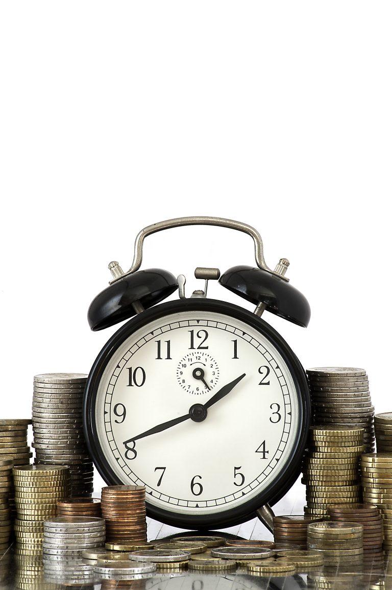 time is money concept: alarm clock and lots of euro coins